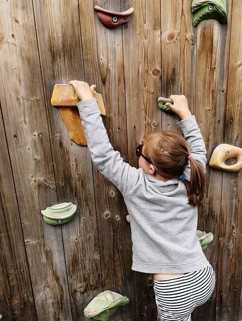 Mädchen klettert auf einer Kletterwand