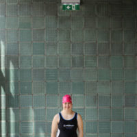 Frau am Rand eines Schwimmbeckens.